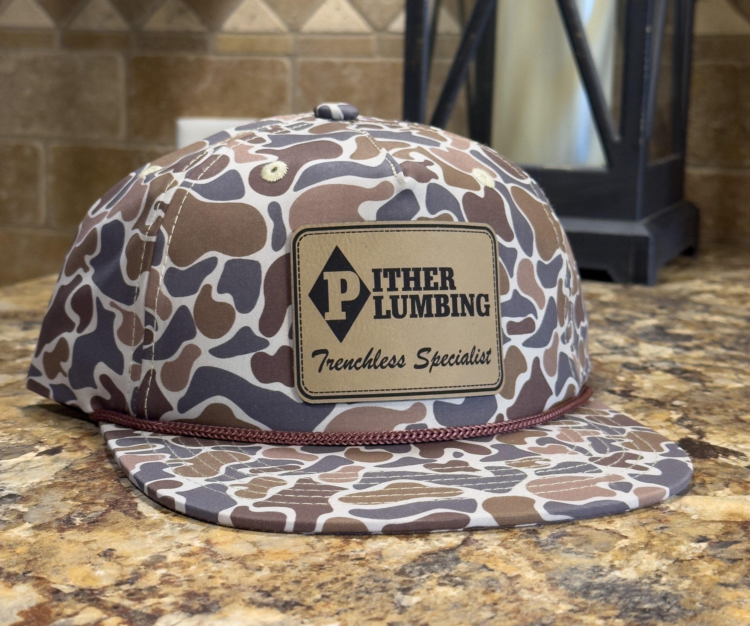 Custom camouflage hat with engraved leather Pither Plumbing patch